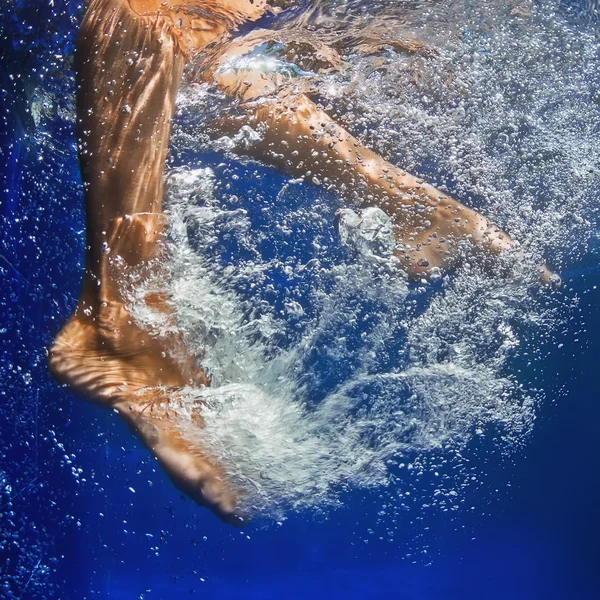 Mädchen, Schwimmen mit Spaß im Erlebnisbad mit sauberen blauen Wasser in Familien-Sommer-Ferien im Resort. Actionfotos von nasse weibliche Füße aktiv bewegt sich unter Wasser mit Blasen und welligkeit Spritzwasser — Photo