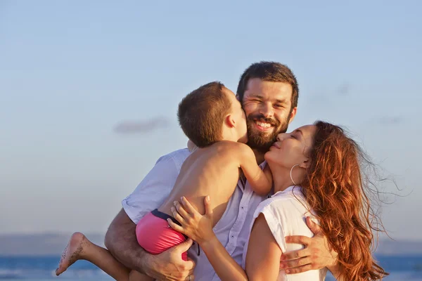 Portret van positieve familie op de zonsondergang strand — Stockfoto