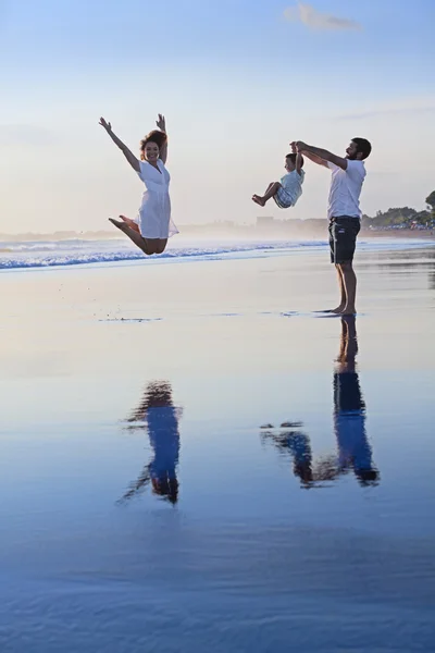 Positive family having fun on black sand sea beach — Stok Foto