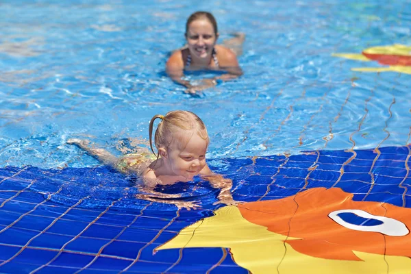 Funny portrait of cheerful baby girl swimming in water park — Stock Photo, Image