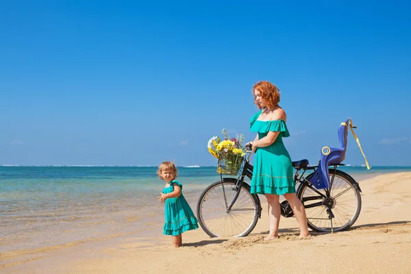 Moeder en dochter met fiets op het zee zand strand — Stockfoto