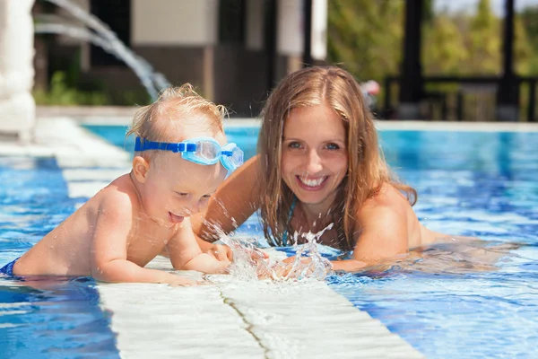 Menino com a mãe nadando com diversão na piscina — Fotografia de Stock