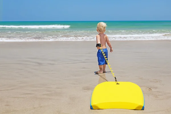 Klein kind zwemmen met bodyboarden op het zee zand strand — Stockfoto