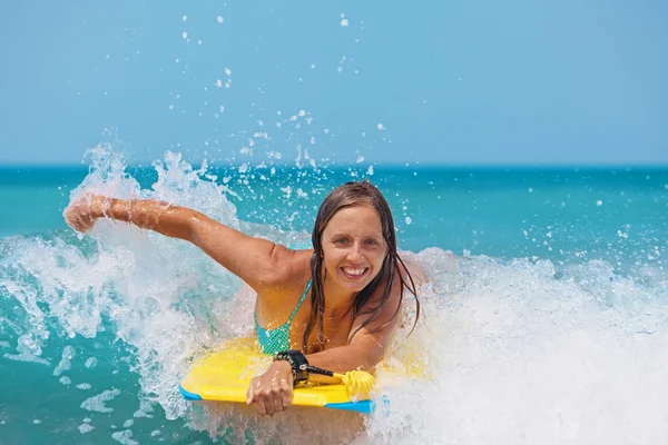 Χαρούμενο κορίτσι κολύμπι με boogie Διοικητικό Συμβούλιο σχετικά με τα κύματα της θάλασσας — Φωτογραφία Αρχείου