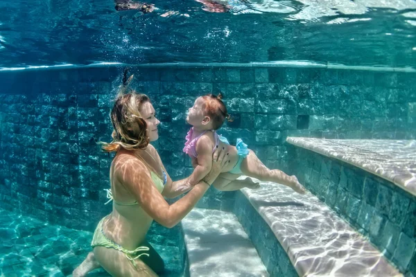 Matka s dítětem, plavání pod vodou v modré pláže pool0 — Stock fotografie