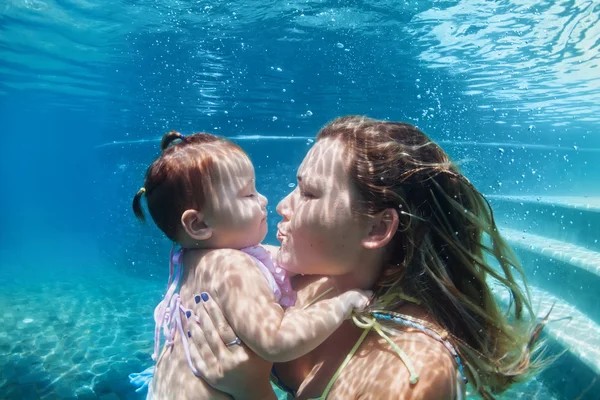 Mãe com criança nadar debaixo d'água na praia azul piscina — Fotografia de Stock