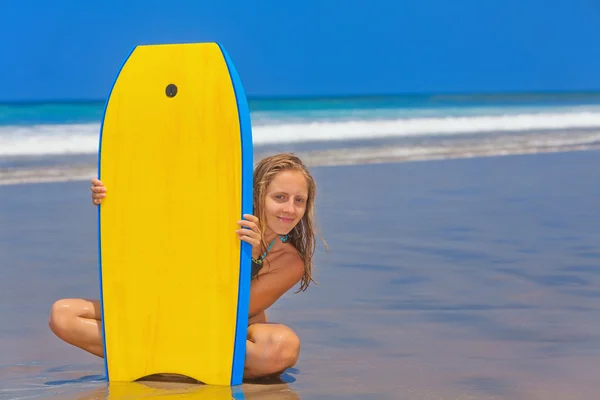 Mooi meisje met surfplank op zee strand met golven — Stockfoto