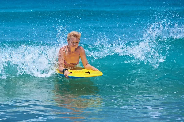 Positieve volwassen vrouw surfen met plezier op oceaan golven — Stockfoto