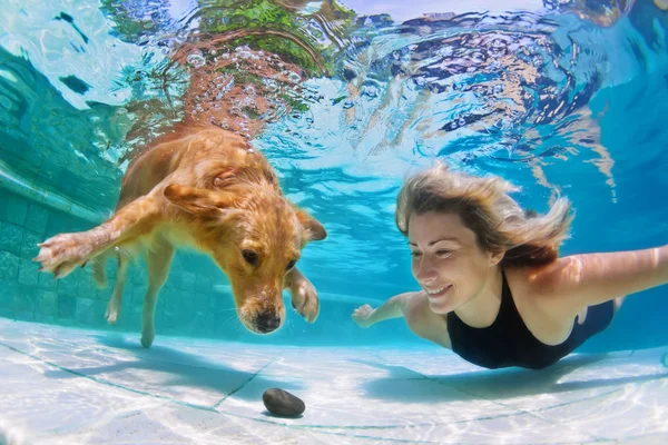 Vrouw met hond onderwater zwemmen — Stockfoto