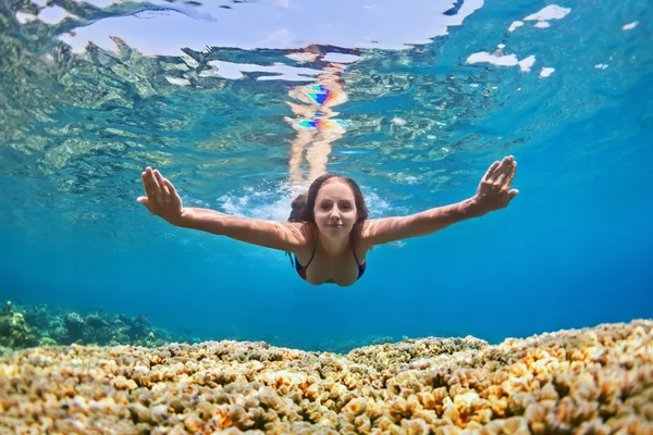 Jonge vrouw duik onderwater over koraalrif in de zee — Stockfoto