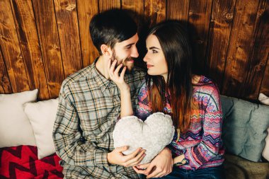 Bir kalp tutan bir çift. Hipsters vintage ahşap zemin üzerine.