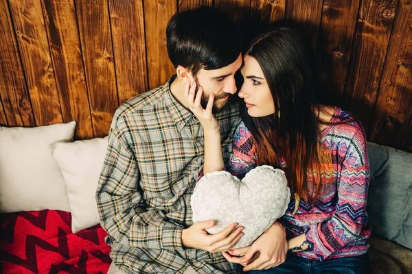 Um casal a segurar um coração. Hipsters em fundo de madeira vintage . — Fotografia de Stock