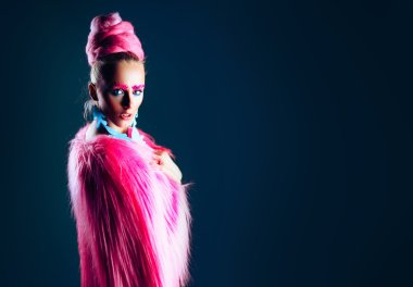 Pembe bir ceket ve mavi küpe mavi gözlü kız modeli. Sanat saç ve makyaj. reklam alanı