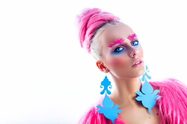 Meisje model met blauwe ogen in een roze jas en blauwe oorbellen. Kunst kapsel en make-up. Op een witte achtergrond. — Stockfoto