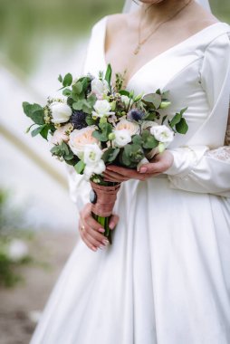 Gelin elinde bir buket çiçekle köy usulü bir düğün buketi tutuyor. Yumuşak odak