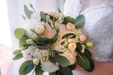 Gelin elinde bir buket çiçekle köy usulü bir düğün buketi tutuyor. Yumuşak odak