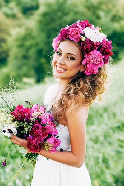 Móda krása Model dívka s květinami ve vlasech ve svatebních šatech. — Stock fotografie
