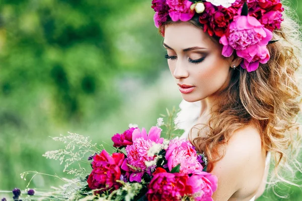Moda beleza modelo menina com flores no cabelo em um vestido de noiva . — Fotografia de Stock