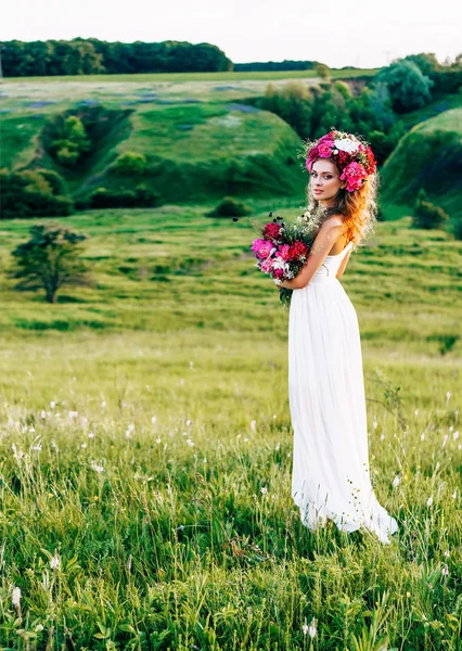 Mode schoonheid Model meisje met bloemen in het haar in een trouwjurk. — Stockfoto
