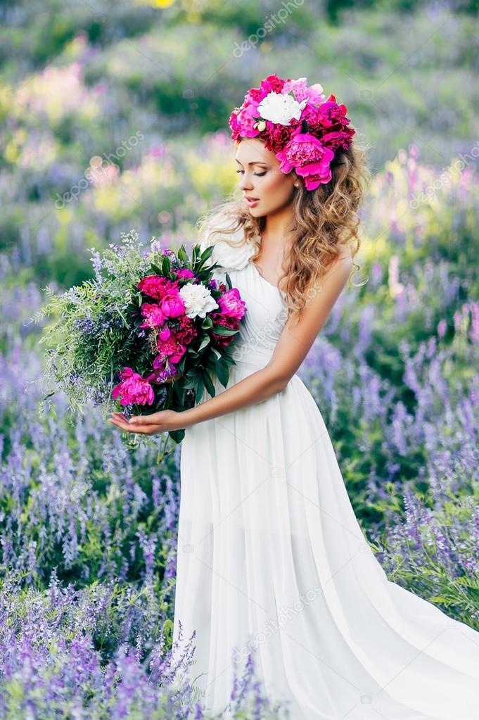 Fashion Beauty Model Girl with flowers in the hair in a wedding dress.