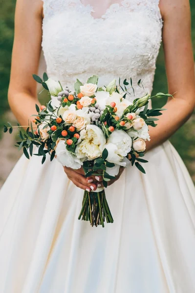 Noiva segurando um buquê de flores em um estilo rústico, buquê de casamento — Fotografia de Stock