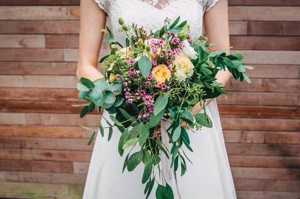 Menyasszony kezében egy csokor virágot, rusztikus stílusban, esküvői csokor — Stock Fotó