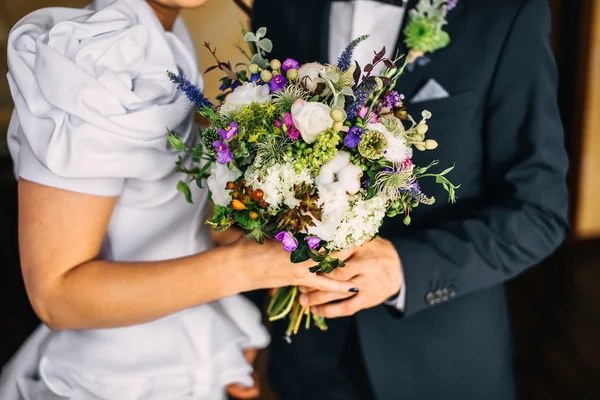 Bräutigam umarmt Braut. Brautstrauß — Stockfoto