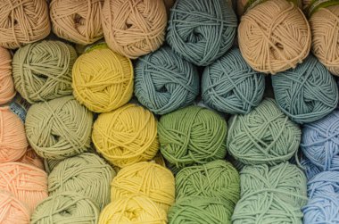 Örgü ve örgü işi için tezgahta bobinli yün ipliği var. Mağazadaki farklı renk iplikleri. Hobi, dikiş ve örgü için mal ticareti..