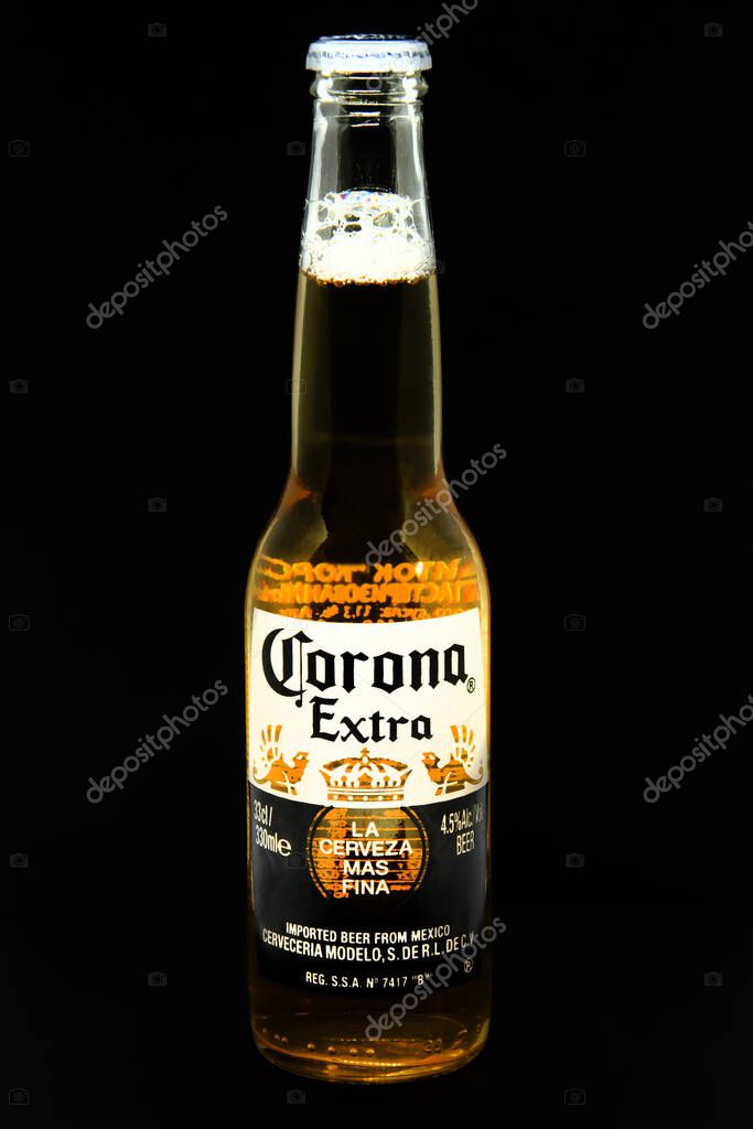 Bottle of light beer Corona Extra produced by Cerveceria Modelo on black background. Corona is most popular imported beer. Selective focus. Moscow Russia - 11.19.2020