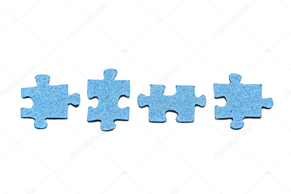 Row of four disconnected blue jigsaw puzzle pieces isolated on white background. Board home games and puzzles. Symbol of quarantine soothing activity. Concept of disunity, inconsistency.