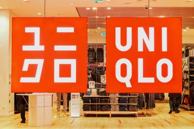 Alışveriş merkezindeki cam vitrinde UNIQLO giyim mağazasının logosu ve markası ile parlayan tabela. UNIQLO, Japon holding şirketi FAST 'ın sekiz markasından en büyüğü. Moskova Rusya 01.10.2021