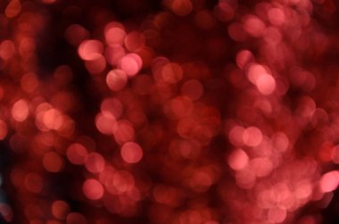 Parlak renkli aydınlatma çemberleri olan soyut bir arkaplan. Kırmızı renkli Bokeh. Parıldayan klasik ışıklar arka planında. Dikkati dağılmış. Kırmızı ışıklarla geçen Sevgililer Günü ve Noel arkaplanı