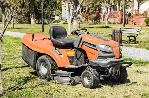 Yana, Türkiye 03.18.2021 Ağır Bahçe traktörü Husqvarna geniş lastikli çimenler için. Yaprakların yanı sıra mükemmel çim kırpma koleksiyonu sunan traktör düzgün kesim sonuçları veriyor..