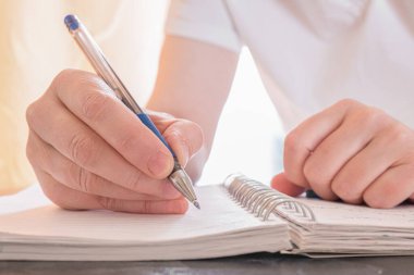 Kalem ve not defteriyle kadın ellerine yakın çekim. Kadın not defterine not alıyor. Eğitim, iş, yazarlık kavramı.