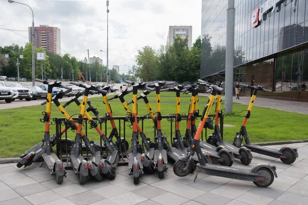 Alışveriş merkezinin yakınındaki meydanda elektrikli scooter park ediyorum. Şehir elektrikli scooter kiralama servisi - Kickshare. Scooter 'lar düzensiz duruyor. Moskova, Rusya - 06.12.2021