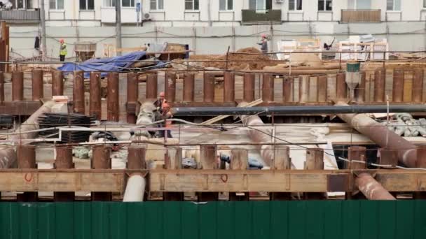 Miğferli Turuncu Yelekli Işçiler Büyük Bir Inşaat Alanında Inşaat Malzemeleri — Stok video