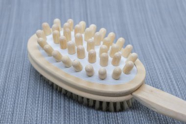 Vücut fırçalamak için çift taraflı masaj fırçası yakın plan. Tirajı artırarak ve lenf sistemini uyararak cildinizin durumunu iyileştirmek için doğal ahşap iğneler.