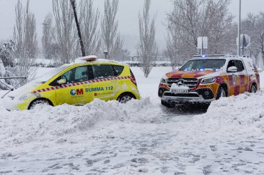 Madrid, İspanya - 9 Ocak 2021 Madrid 'de kar kaplı caddelerde acil durum hizmetleri dolaşmaktadır. Fırtına Filomena. Madrid 'de şiddetli kar yağışı var. Kar kaplı arabalar.