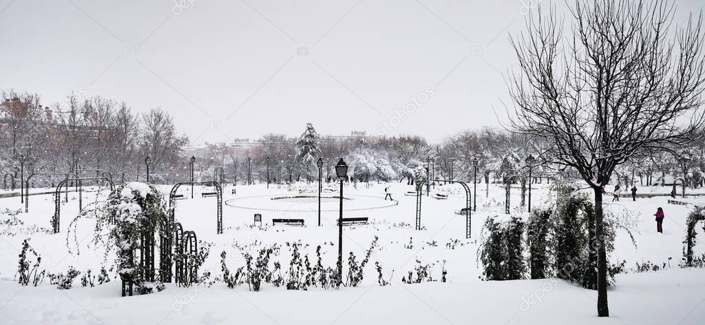 Madrid, Spain- January 9, 2021: Parks of Madrid frozen by snow, Storm Filomena. Great snowfall in Madrid. Snow covered cars.