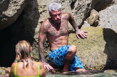 Formentera, İspanya... 12 Ağustos 2019: Ünlü rapçi Fedez Formentera 'da tatilin tadını çıkarıyor. Rapçi Fedez uçurumun kenarında. Rapçi Fedez Akdeniz 'in sularında yüzüyor.