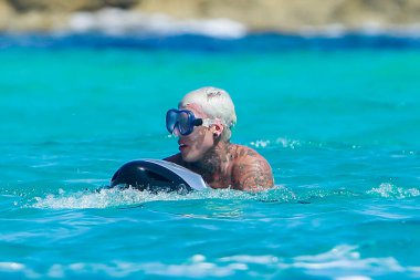 Formentera, İspanya... 12 Ağustos 2019: Ünlü rapçi Fedez Formentera 'da tatilin tadını çıkarıyor. Rapçi Fedez uçurumun kenarında. Rapçi Fedez Akdeniz 'in sularında yüzüyor.