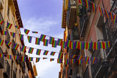Madrid, Spain: Decoration with the rainbow flags of gay pride in the streets and facades of the streets of Madrid. Pride festivals in Madrid clipart