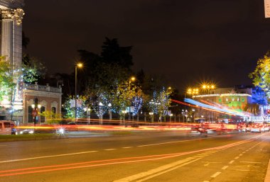 Madrid, İspanya, 28 Kasım 2020: Alcala Caddesi Noel sezonu ve araçların izleriyle aydınlatılmıştır. Arka planda Cibeles Meydanı 'nı görebilirsiniz..