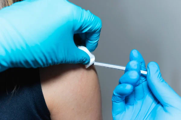 Pracownik Służby Zdrowia Podaje Szczepionkę Wstrzykuje Jedną Ręką Trzymając Wacik Obrazek Stockowy