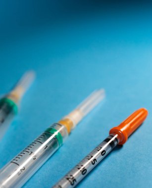 Sol alt köşeden görünen üç şırınganın dikey görüntüsü, üstte kopya alanı bırakıyor.