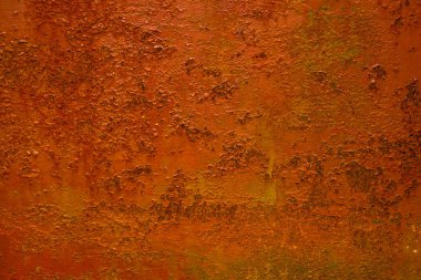 Açık havada çürümüş bir metalin üzerine turuncuya boyanmış soyut renkli bir resim.