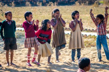 Kızlar okulda oynarken gülümsüyor. Hindistan 'da kaynakları kısıtlı olan çocuklar Kâr amacı gütmeyen örgütün sağladığı gayri resmi eğitime güveniyorlar. Hiçbir şey onları mutlu olmaktan alıkoyamaz. Bu aynı zamanda spor yapma fırsatıdır..