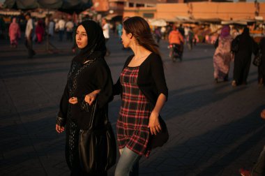Marakeş, Fas. 08-10 / 2018. Jemaa El Fna, Marakeş 'in Medina mahallesindeki (eski şehir) ana meydan ve pazardır. Yürüyen iki genç bayan arkadaş.