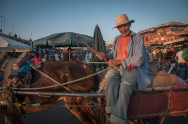 Marakeş, Fas. 08-10 / 2018. Jemaa El Fna, Marakeş 'in Medina mahallesindeki (eski şehir) ana meydan ve pazardır. Yaşlı adam at üstünde mal taşıyor..
