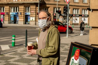 Prag, Çek Cumhuriyeti. 04-17-2020. Coronavirus yüzünden insanlar Prag 'a taşınırken tedbir alıyorlar. Elektronik Üniversitesi 'ne yakın bir bardan bira içen adam..